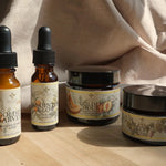 Four skincare products in the Deep Moisture Routine for Dry Skin with labels on a wooden surface.