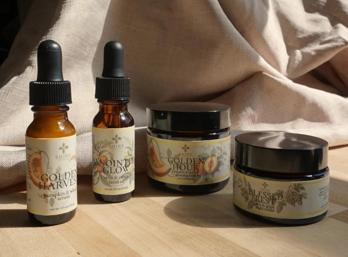 Four skincare products in the Deep Moisture Routine for Dry Skin with labels on a wooden surface.