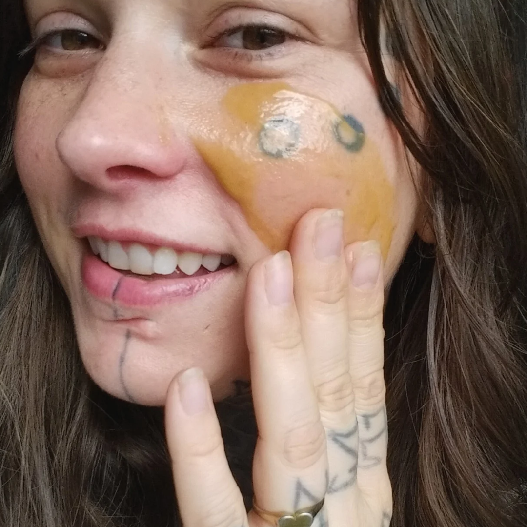 Person washing their face with biblical skincare product called "Golden Hour Cleansing Balm" showing the creamy texture.